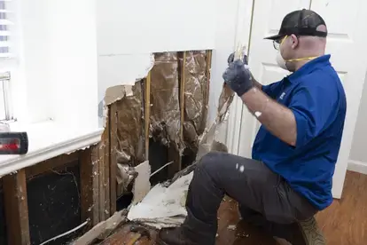 Restoration Technician removing damaged drywall