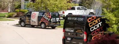 COIT vans parked in front of a house